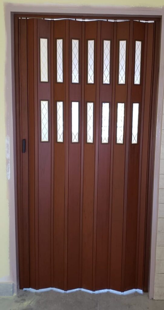 Puerta plegadiza de PVC símil madera con vidrios